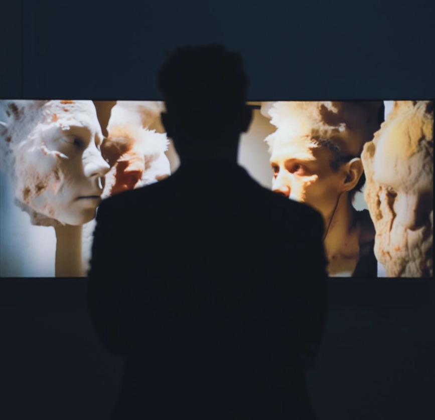 Gianluca Boccadifuoco silhouetted in front of a digital artwork